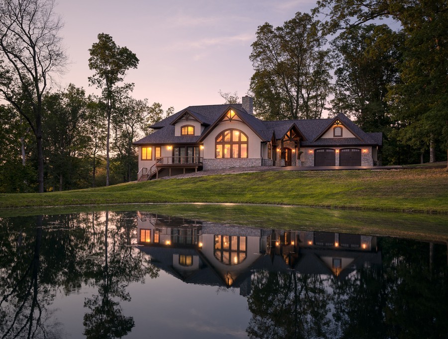 A home’s exterior illuminated by landscape lighting at sunset. 