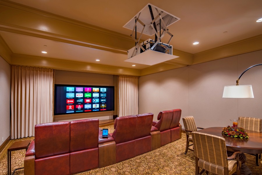 A stylish home theater setup featuring traditional theater seating along with a table with chairs.