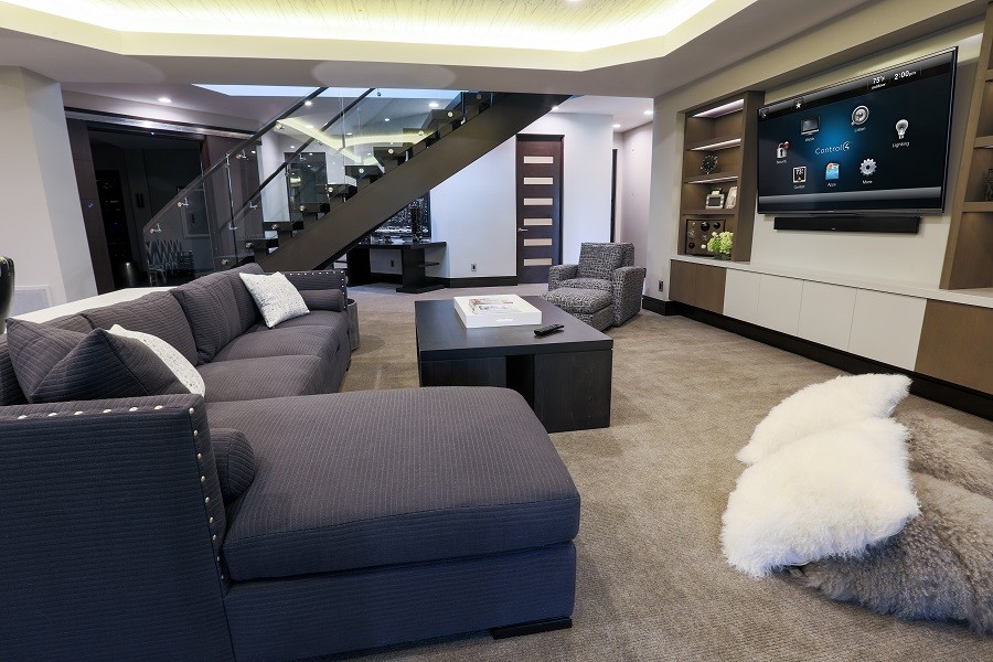 Sophisticated and modern media room with glass and chrome accents and stylishly comfortable furniture.